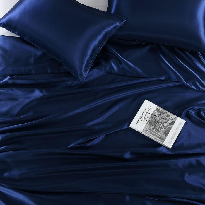 Blue satin sheet set with a book on it - Manchester Collection