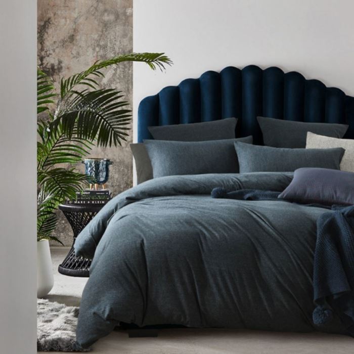 A bed with navy Jersey quilt cover from Machester Collection