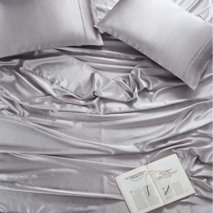 Silver bed sheet from Manchester Collection and a book