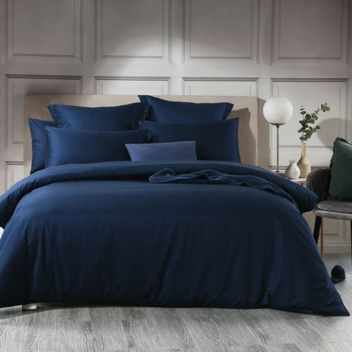 A bed with Navy Soho Quilt Cover from Manchester Collection