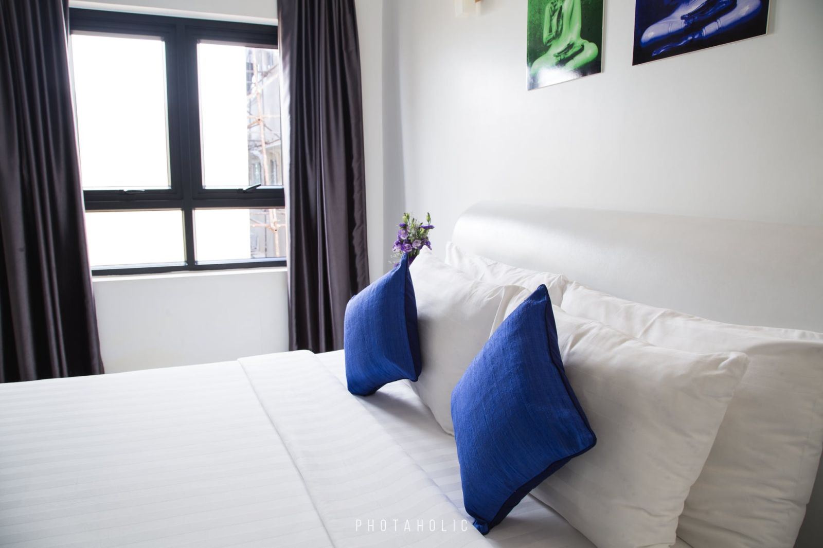 A bed with navy blue pillows.