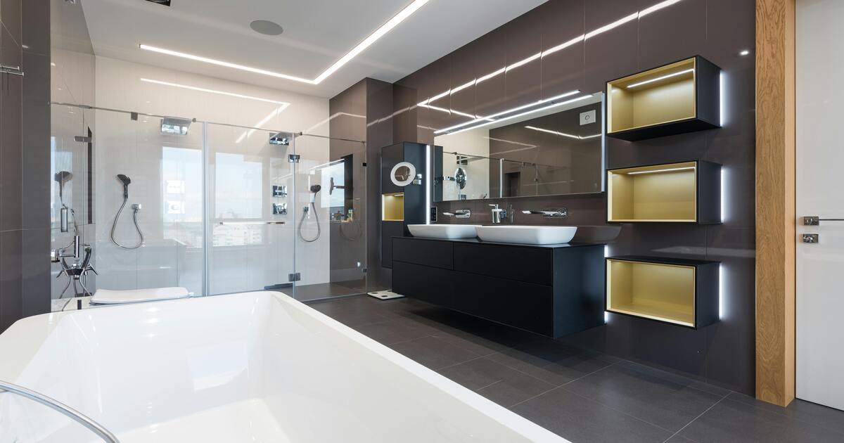 A hotel-inspired bathroom with black marble tiles and a white tub.