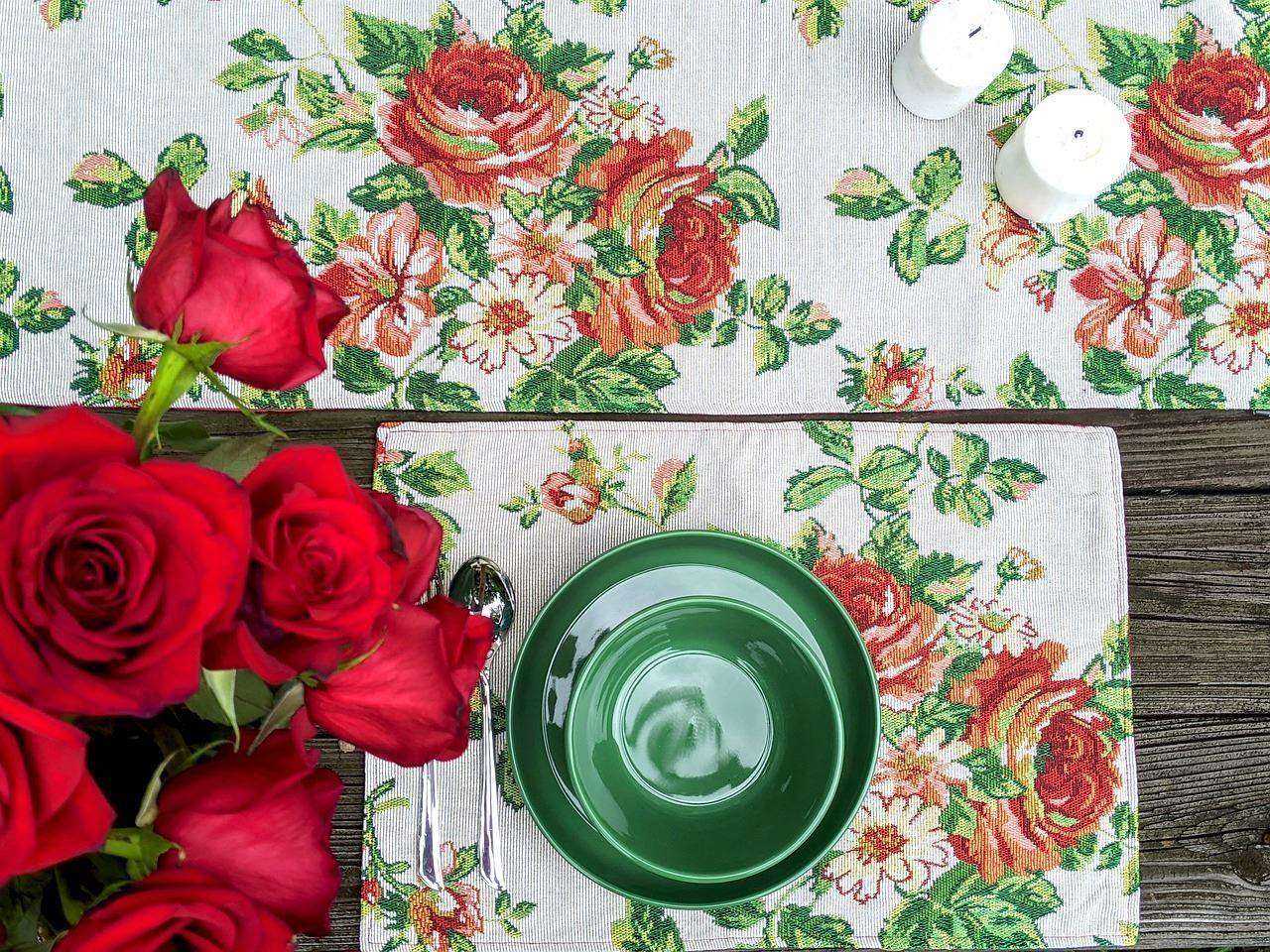 A floral table runner and floral placemat on a table.